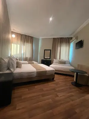 a hotel room with two beds and a table at Cadé Hotel in Casablanca