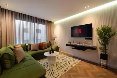 a living room with a green couch and a tv at Cosy & So Stylish Appartement Au coeur de Casablanca Bd 2 Mars Derrière Kfc 2 Min à Pieds vers Mcdo in Casablanca