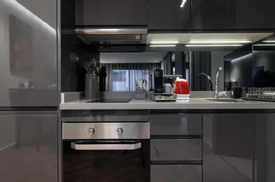a kitchen with black cabinets and a stainless steel sink at Cosy & So Stylish Appartement Au coeur de Casablanca Bd 2 Mars Derrière Kfc 2 Min à Pieds vers Mcdo in Casablanca
