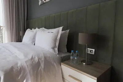 a bedroom with a white bed with a green headboard at Beautifully Designed 3BR Apartment+ Panoramic View in Rabat