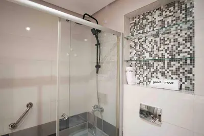 a shower with a glass door in a bathroom at Beautifully Designed 3BR Apartment+ Panoramic View in Rabat