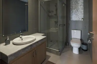 a bathroom with a sink and a shower and a toilet at Beautifully Designed 3BR Apartment+ Panoramic View in Rabat