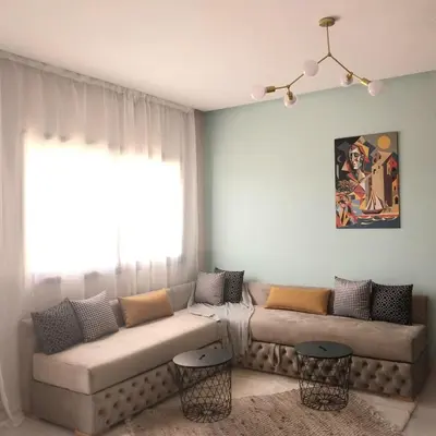 a living room with a couch and a window at top apartment Airport Mohamed 5 in Derroua