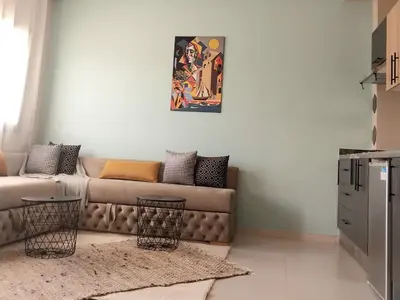 a living room with a couch and a painting on the wall at top apartment Airport Mohamed 5 in Derroua