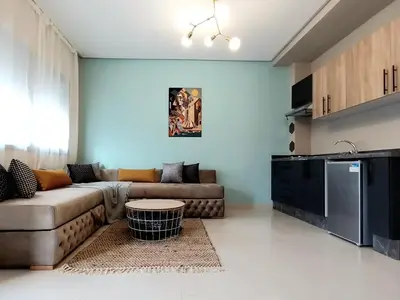 a living room with a couch and a table at top apartment Airport Mohamed 5 in Derroua