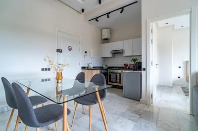 a dining room with a glass table and chairs at AeroSuite in Nouaceur