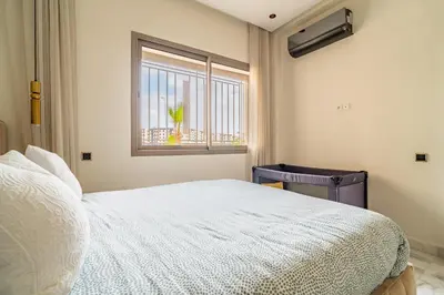a bedroom with a white bed and a window at AeroSuite in Nouaceur
