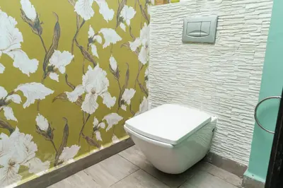 a bathroom with a toilet with a flower wallpaper at Luxury villa Bouskoura Pearl in Casablanca