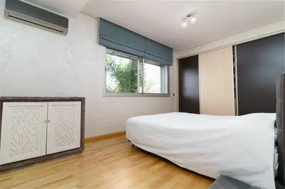 a bedroom with a large white bed and a window at Luxury villa Bouskoura Pearl in Casablanca