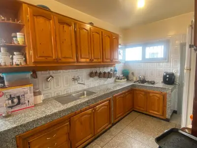 a kitchen with wooden cabinets and a sink at Spacieux et familial à 2 minutes à pied du stade de football de RABAT in Rabat