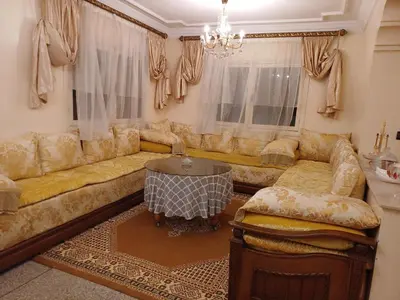 a living room with a couch and a table at Spacieux et familial à 2 minutes à pied du stade de football de RABAT in Rabat