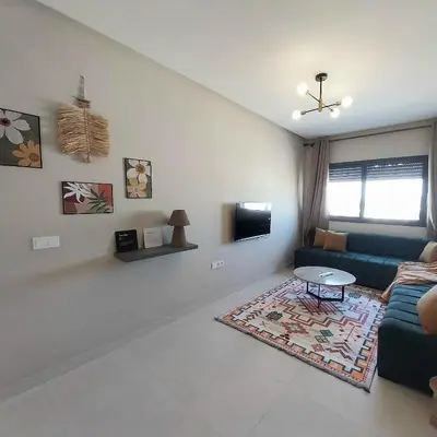 a living room with a couch and a table at Airport mohamed 5 break apartments in Derroua
