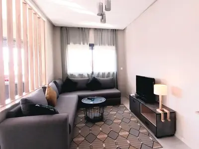 a living room with a couch and a tv at Airport mohamed 5 break apartments in Derroua