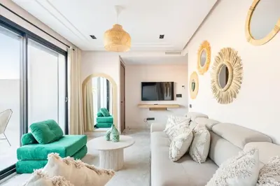 a living room with a white couch and green chairs at TTHOLIDAYS Cosy Apartment Casablanca City Center in Casablanca