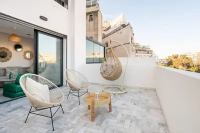 a balcony with chairs and a table on a building at TTHOLIDAYS Cosy Apartment Casablanca City Center in Casablanca