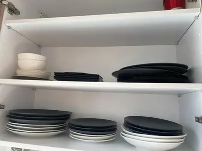 a shelf filled with black and white plates and bowls at Maarif , Cosy 2 Chambres, Parking wifi Netflix Gratuit in Casablanca