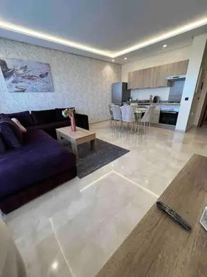 a living room with a purple couch and a kitchen at Luxury flat at Casa Finance city in Casablanca