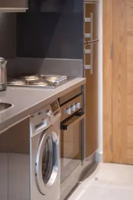 a kitchen with a washing machine under a counter at Charming apartment at Maarif in Casablanca