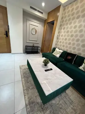 a living room with a green couch and a table at Charming apartment at Maarif in Casablanca