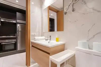 a white bathroom with a sink and a stove at Charming apartment at Maarif in Casablanca