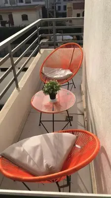 two orange chairs and a table on a balcony at Charming apartment at Maarif in Casablanca