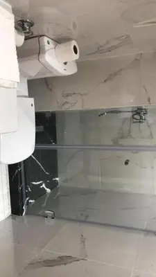 a bathroom with a glass shower with a roll of toilet paper at Charming apartment at Maarif in Casablanca