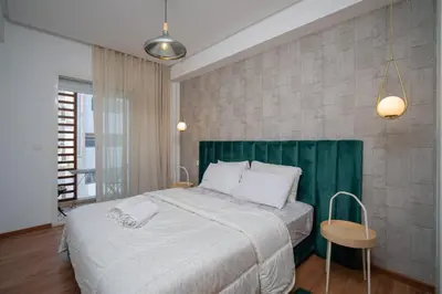 a bedroom with a large bed with a green headboard at studio Maarif à 3min à pied du stade med V in Casablanca