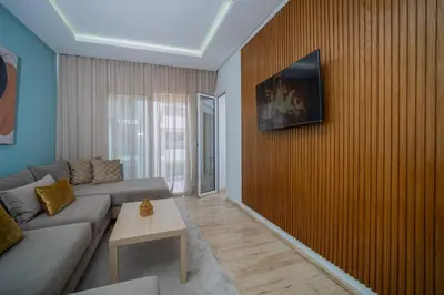 a living room with a couch and a wooden wall at studio Maarif à 3min à pied du stade med V in Casablanca