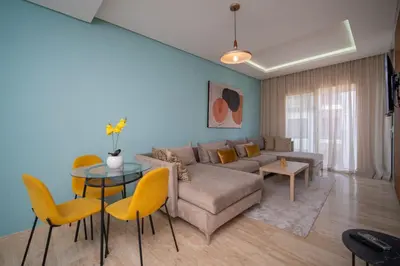 a living room with a couch and a table and chairs at studio Maarif à 3min à pied du stade med V in Casablanca