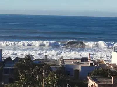 a large wave in the ocean with a building at Luxury Villa Jack Beach Resort Ocean Oasis View Panoramic in Casablanca