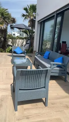 a patio with three chairs and a couch and a table at Luxury Villa Jack Beach Resort Ocean Oasis View Panoramic in Casablanca