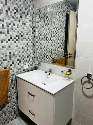 a bathroom with a white sink and a mirror at Harhoura Modern Flat in Temara