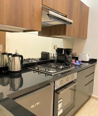 a kitchen with a stove top oven in a kitchen at Take a cosy rest Near the airport in Nouaceur