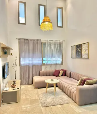 a living room with a couch and a table at Take a cosy rest Near the airport in Nouaceur