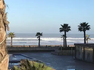a view of a beach with palm trees and the ocean at Ocean View Apartment - Anfa Place - in Casablanca