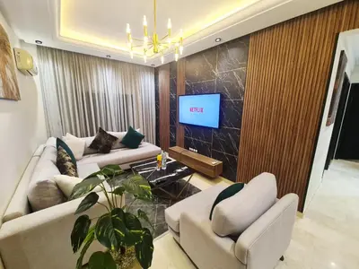 a living room with two couches and a tv at modern apartment opposite to HASSAN2 MOSQUE & FAIR international casablanca , near downtwn, with side SEA view with sports machines with free underground GARAGE prohibited for unmarried couples of Arab original apartment too QUIET in Casablanca