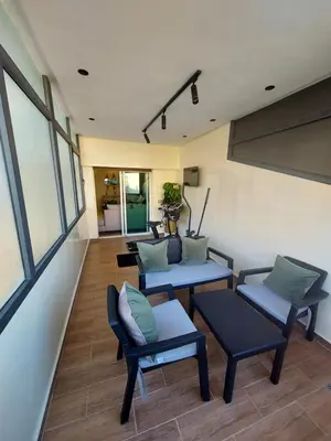 a living room with two chairs and a table at modern apartment opposite to HASSAN2 MOSQUE & FAIR international casablanca , near downtwn, with side SEA view with sports machines with free underground GARAGE prohibited for unmarried couples of Arab original apartment too QUIET in Casablanca
