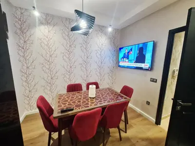 a dining room with a table and red chairs at modern apartment opposite to HASSAN2 MOSQUE & FAIR international casablanca , near downtwn, with side SEA view with sports machines with free underground GARAGE prohibited for unmarried couples of Arab original apartment too QUIET in Casablanca