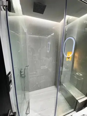 a shower with a glass door in a bathroom at modern apartment opposite to HASSAN2 MOSQUE & FAIR international casablanca , near downtwn, with side SEA view with sports machines with free underground GARAGE prohibited for unmarried couples of Arab original apartment too QUIET in Casablanca