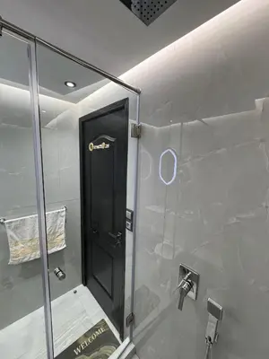a bathroom with a shower with a black door at modern apartment opposite to HASSAN2 MOSQUE & FAIR international casablanca , near downtwn, with side SEA view with sports machines with free underground GARAGE prohibited for unmarried couples of Arab original apartment too QUIET in Casablanca