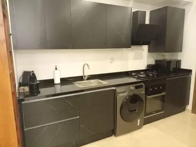 a kitchen with a sink and a washing machine at Appartement Parc Mohammedia in Mohammedia