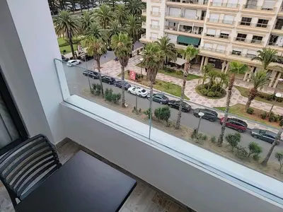 a window with a view of a street with palm trees at Appartement Parc Mohammedia in Mohammedia