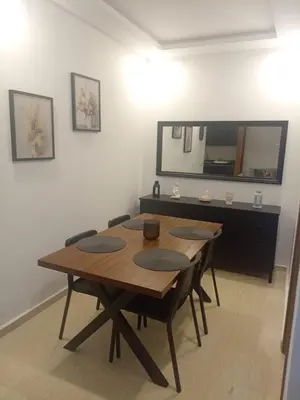 a dining room table with chairs and a mirror at Appartement Parc Mohammedia in Mohammedia