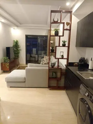 a living room with a bed and a kitchen at Appartement Parc Mohammedia in Mohammedia