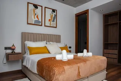 a bedroom with a large bed with yellow pillows at Appartement neuf 2 chambres avec salle de sport in Casablanca