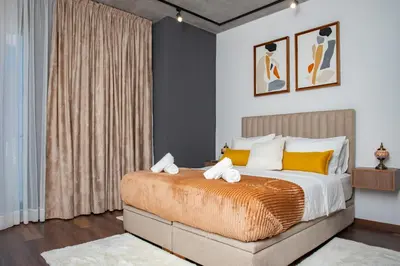 a bedroom with a large bed with yellow pillows at Appartement neuf 2 chambres avec salle de sport in Casablanca