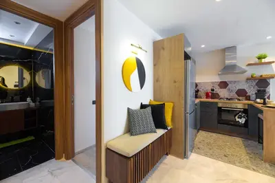 a room with a kitchen with a chair in it at Appartement luxueux et lumineux Maarif Casablanca in Casablanca
