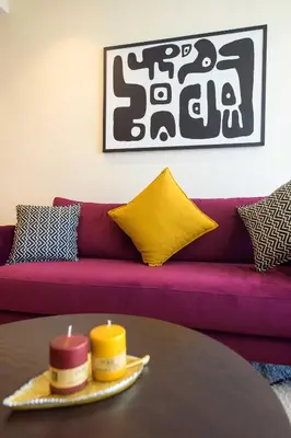 a purple couch with two candles on a table at Appartement luxueux et lumineux Maarif Casablanca in Casablanca