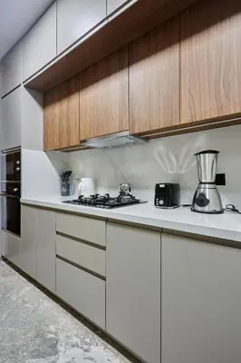 a kitchen with white counters and wooden cabinets at Modern Unit in Casa Finance City With Free Parking in Casablanca