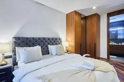 a bedroom with a large white bed with a gray headboard at Modern Unit in Casa Finance City With Free Parking in Casablanca